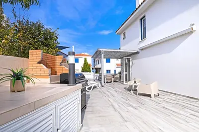 a backyard with a wooden deck with a table and chairs at Villa Amy - 100m from Nisia Loumbardi Beach in Protaras