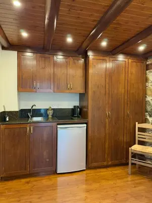 a kitchen with wooden cabinets and a white refrigerator at To Petrino 4 Studio- Nature, Comfort & Tradition Under One Roof in Kalopanayiotis