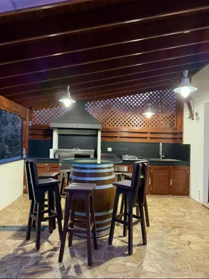 a bar with chairs and a barrel in a kitchen at To Petrino 4 Studio- Nature, Comfort & Tradition Under One Roof in Kalopanayiotis