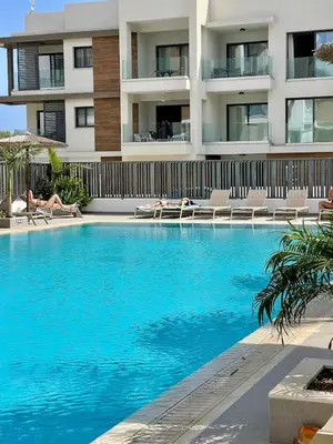 a swimming pool in front of a building at Fall In Paradise in Paralimni