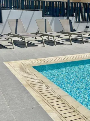 two lounge chairs sitting next to a swimming pool at Fall In Paradise in Paralimni