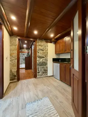 a kitchen with wooden cabinets and a wooden floor at To Petrino 5 -Apartment- Nature, Comfort & Tradition Under One Roof in Kalopanayiotis