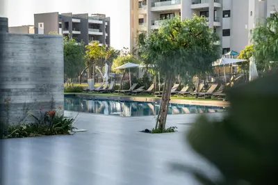 a swimming pool with a tree in the middle at Luxe One Residence in Aglantzia