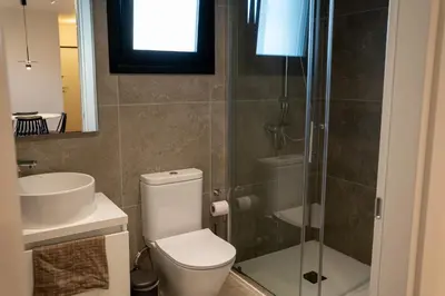 a bathroom with a toilet and a sink and a shower at Luxe One Residence in Aglantzia