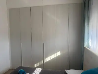 a bedroom with a large white cabinet with a bed at The Qube Residence 2 Bedroom Premium Apartment in Limassol