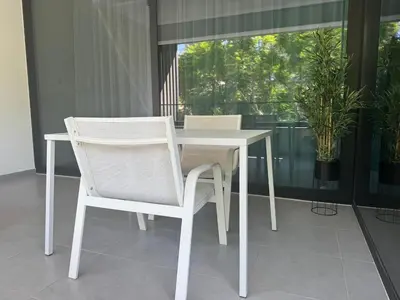a white table and chairs in a room with a window at The Qube Residence 2 Bedroom Premium Apartment in Limassol