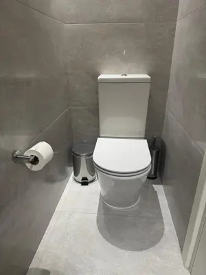a bathroom with a toilet and a roll of toilet paper at The Qube Residence 2 Bedroom Premium Apartment in Limassol