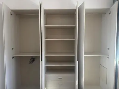 a white walk in closet with white shelves at The Qube Residence 2 Bedroom Premium Apartment in Limassol