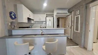 a kitchen with two white chairs and a counter at STAY Armonia Central Suite in Nicosia