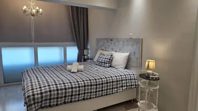 a bedroom with a bed with a checkered blanket at STAY Armonia Central Suite in Nicosia