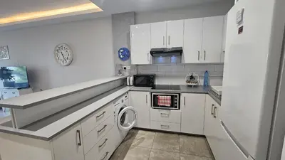a kitchen with white cabinets and a washer and dryer at STAY Armonia Central Suite in Nicosia