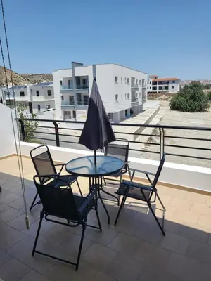 a patio table with chairs and an umbrella on a balcony at Sea View Valley Retreat in Voroklini