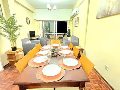 a wooden table with plates on it in a room at Breathtaking Beachfront Apartment in Makenzy in Larnaka