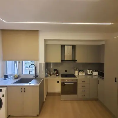 a kitchen with white cabinets and a stove top oven at Amato Beach in Limassol