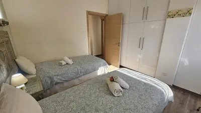 a bedroom with two beds with towels on the floor at STAY Vintage Central Suite in Nicosia