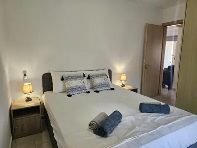 a bedroom with a large white bed with blue pillows at Horizon View 2 in Kiti