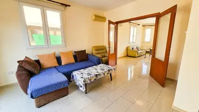 a living room with a blue couch and a window at Townbeach Villa with Private Pool in Voroklini