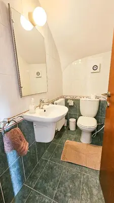 a bathroom with a sink and a toilet and a mirror at Townbeach Villa with Private Pool in Voroklini