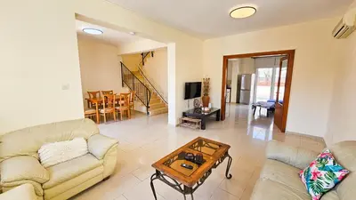 a living room with a couch and a table at Townbeach Villa with Private Pool in Voroklini