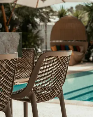 two chairs sitting at a table near a pool at Averde Residence in Larnaka