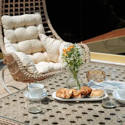 a table with a plate of pastries and a vase of flowers at Averde Residence in Larnaka