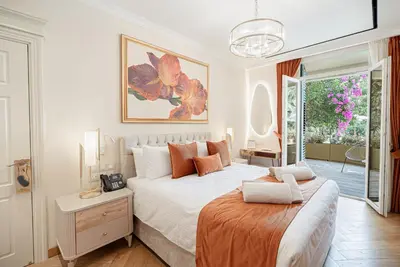 a white bedroom with a large bed and a window at Averde Residence in Larnaka