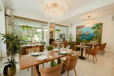 a dining room with tables and chairs and a chandelier at Averde Residence in Larnaka