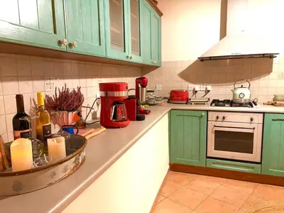 a kitchen with green cabinets and a counter top at The Lodge Kampi by Thea Suites