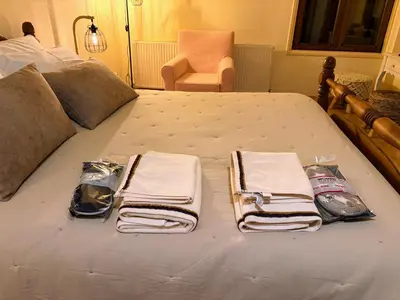 a bed with towels and a pile of towels on it at The Lodge Kampi by Thea Suites