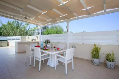 a white table and white chairs on a patio at Villa Posidonas 3 in Protaras