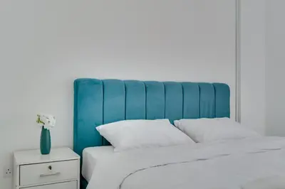 a bed with a blue headboard and white pillows at Elisabeth Salt Lake views 200m from Makenzy beach in Larnaka