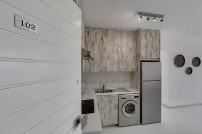 a kitchen with white cabinets and a washer and dryer at Elisabeth Salt Lake views 200m from Makenzy beach in Larnaka