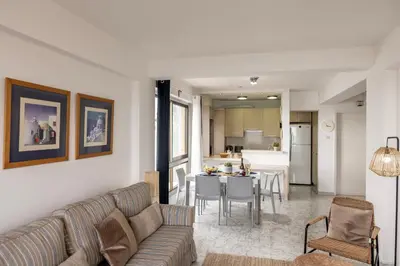a living room with a couch and a table at Mackenzie Beachfront Suite in Larnaka