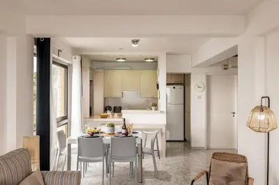 a kitchen and dining room with a table and chairs at Mackenzie Beachfront Suite in Larnaka