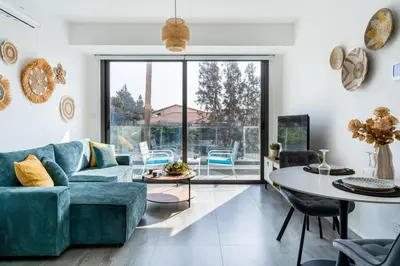 a living room with a blue couch and a table at Azoria - Stylish 1-BR Apartment & Balcony in Kiti in Kiti