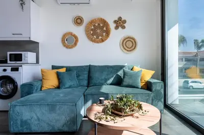 a living room with a blue couch and a table at Azoria - Stylish 1-BR Apartment & Balcony in Kiti in Kiti