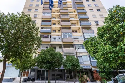 a tall building with trees in front of it at Bastia - Skyline 1-BR Apt & Balcony in Nicosia in Nicosia