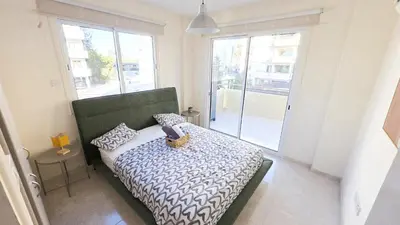 a bedroom with a bed in a room with a window at 2BR Apartment with Pool & Free Wi-Fi in Larnaka