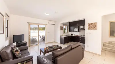 a living room with a couch and a table at EcoHarmony Villa in Paralimni