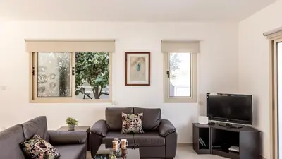 a living room with a couch and a flat screen tv at EcoHarmony Villa in Paralimni