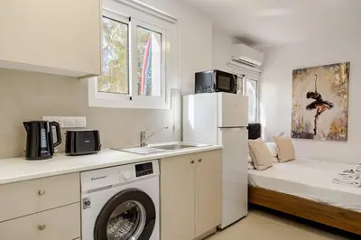 a kitchen with a washer and a sink and a refrigerator at Urban Bay Studios in Limassol