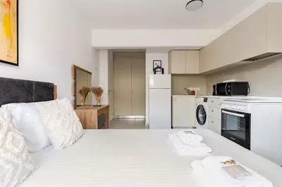 a bedroom with a white bed with two towels on it at Urban Bay Studios in Limassol