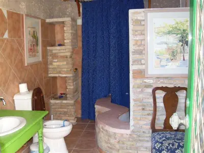 a bathroom with a stone shower with a toilet and a sink at Historic 600 years old beautifully renovated Mill House in Meniko