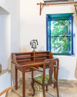 a wooden desk with a chair next to a window at The Historical Cypriot House, Beautifully Renovated Traditional Stone House in Ayios Ioannis