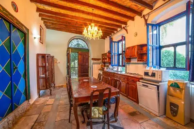 a large kitchen with a wooden table and a chandelier at The Historical Cypriot House, Beautifully Renovated Traditional Stone House in Ayios Ioannis