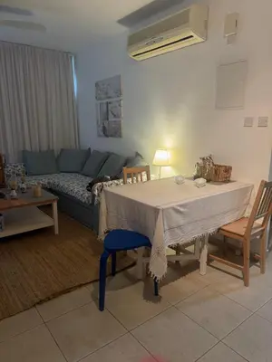 a living room with a table and a couch at A Home at Coralli - Protaras Beach Apartment, 30 m from beach in Protaras