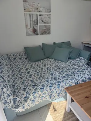 a couch in a living room with a blue and white blanket at A Home at Coralli - Protaras Beach Apartment, 30 m from beach in Protaras