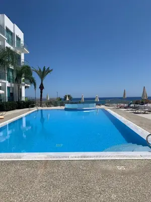 a large blue swimming pool in front of a building at A Home at Coralli - Protaras Beach Apartment, 30 m from beach in Protaras