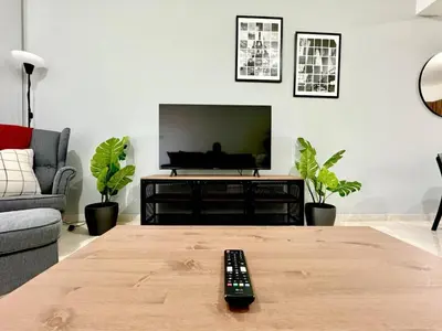 a living room with a television and a remote control on a table at Bright & cozy apartment in Livadia in Livadhia