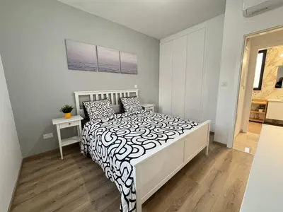 a bedroom with a bed with a black and white comforter at Bright & cozy apartment in Livadia in Livadhia
